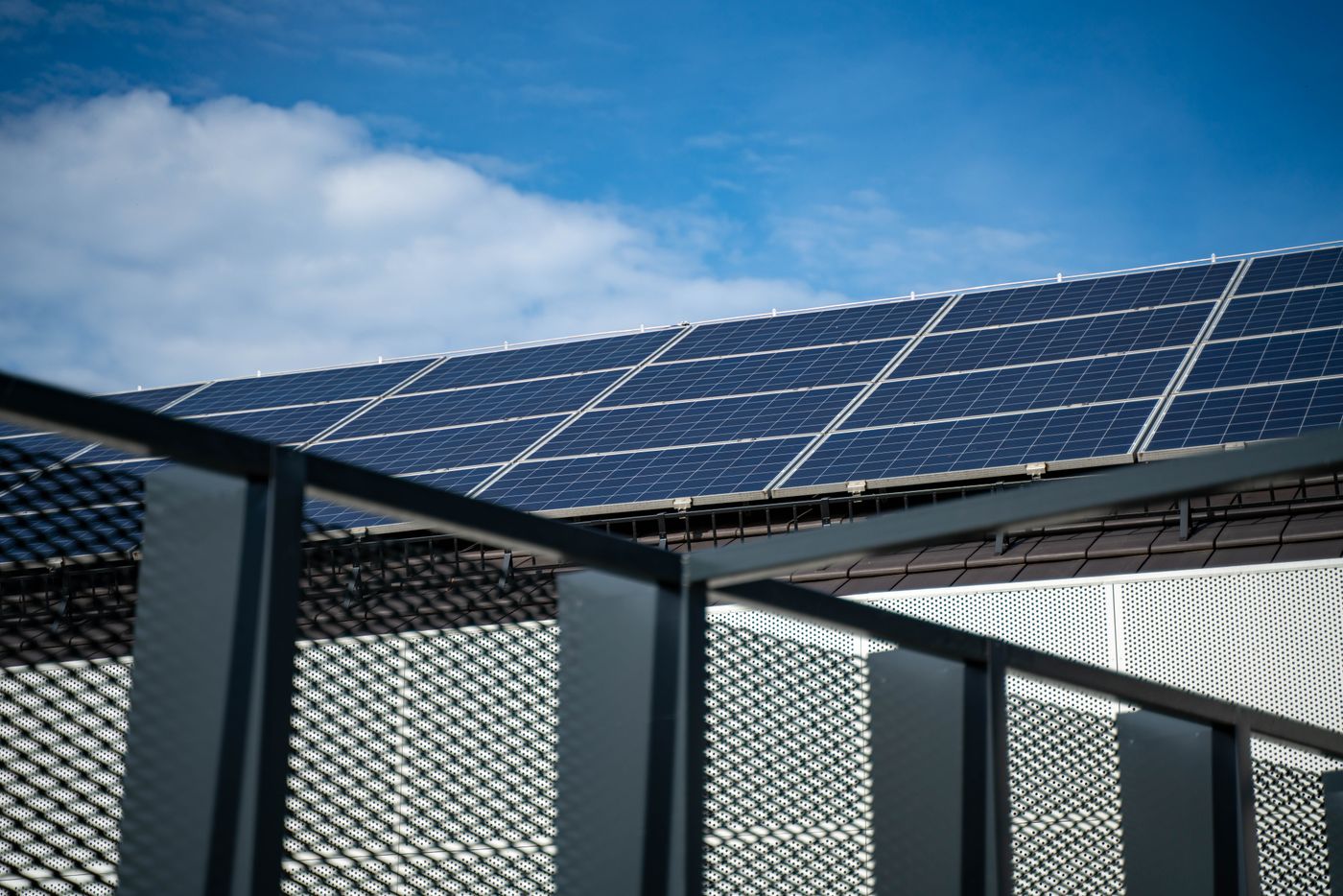 Photovoltaic panels covering a rooftop under a clear blue sky